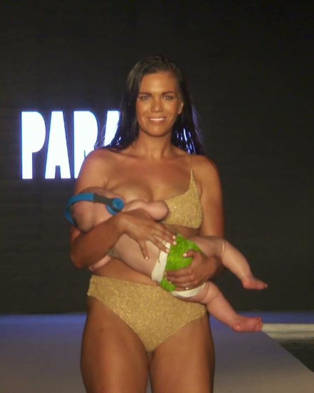 Mara Martin breastfeeds while walking the #SISwimSearch Runway